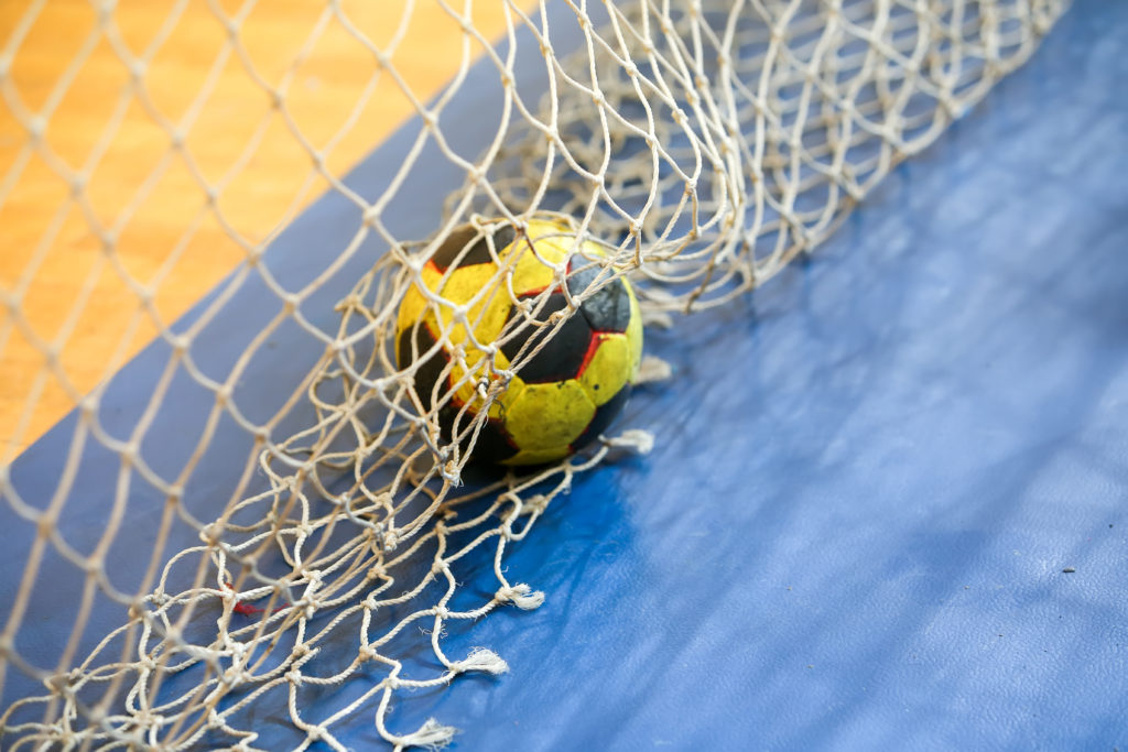 En handboll ligger på golvet i ett handbollsmål.