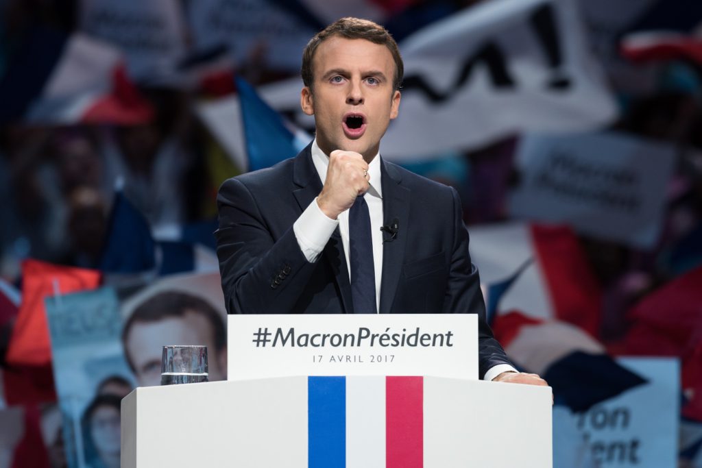 Macron står i en talarstol med knuten näve.