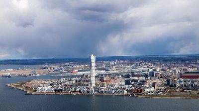 Utsikt över Malmö från luften ovanför vattnet. I mitten syns Turning Torso.