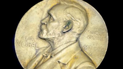 Ett stort gyldmynt med en avbildning av Alfred Nobel.
