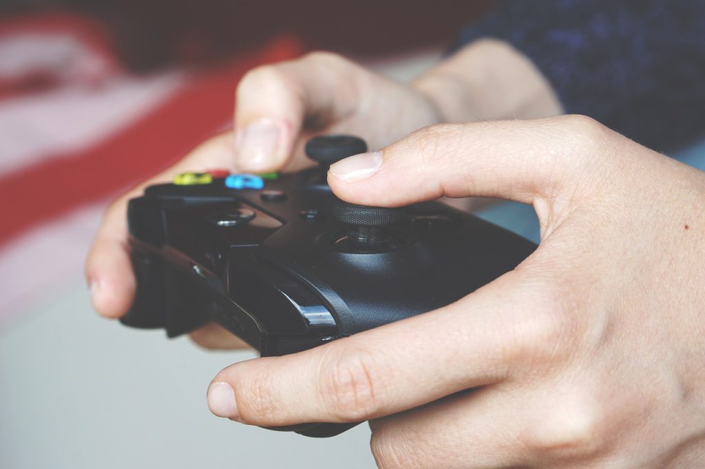 Bild på två händer som håller i en spelkonsol för TV-spel.