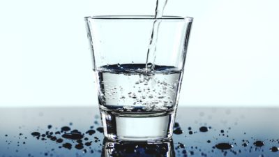 Vatten hälls i ett vattenglas.