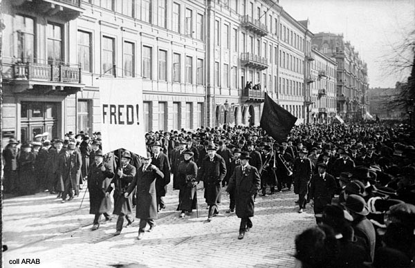 En gammal bild från 1917. På bilden syns ett demonstrationståg. Längst fram i tåget hålls en skylt upp där det står "Fred".