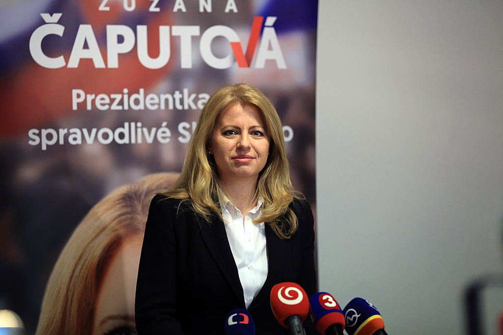 Bild på Zuzana Caputová som står framför flera mikrofoner redo att bli intervjuad av journalister.