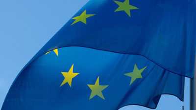 EU:s flagga som blå med gula stjärnor i en ring.