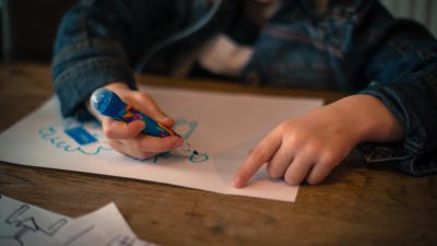 En flicka som ritar på ett papper.