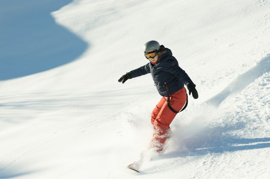 En snowboardåkare som åker nerför en snötäckt backe.