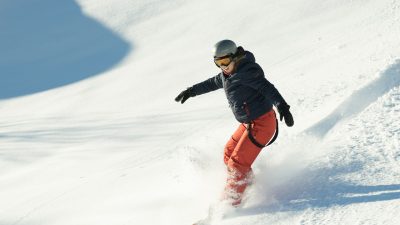 En snowboardåkare som åker nerför en snötäckt backe.