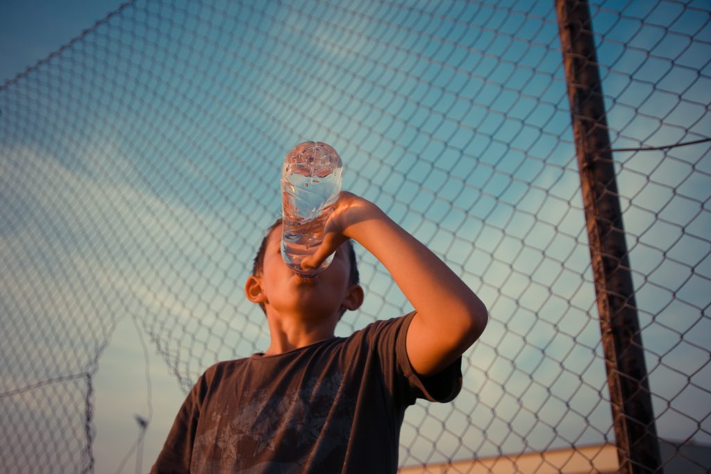En pojke dricker vatten
