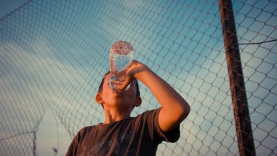 En pojke dricker vatten