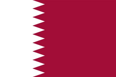 Landet Qatars flagga. Den är vit och vinröd. Färgerna möts i ett sicksack-mönster.